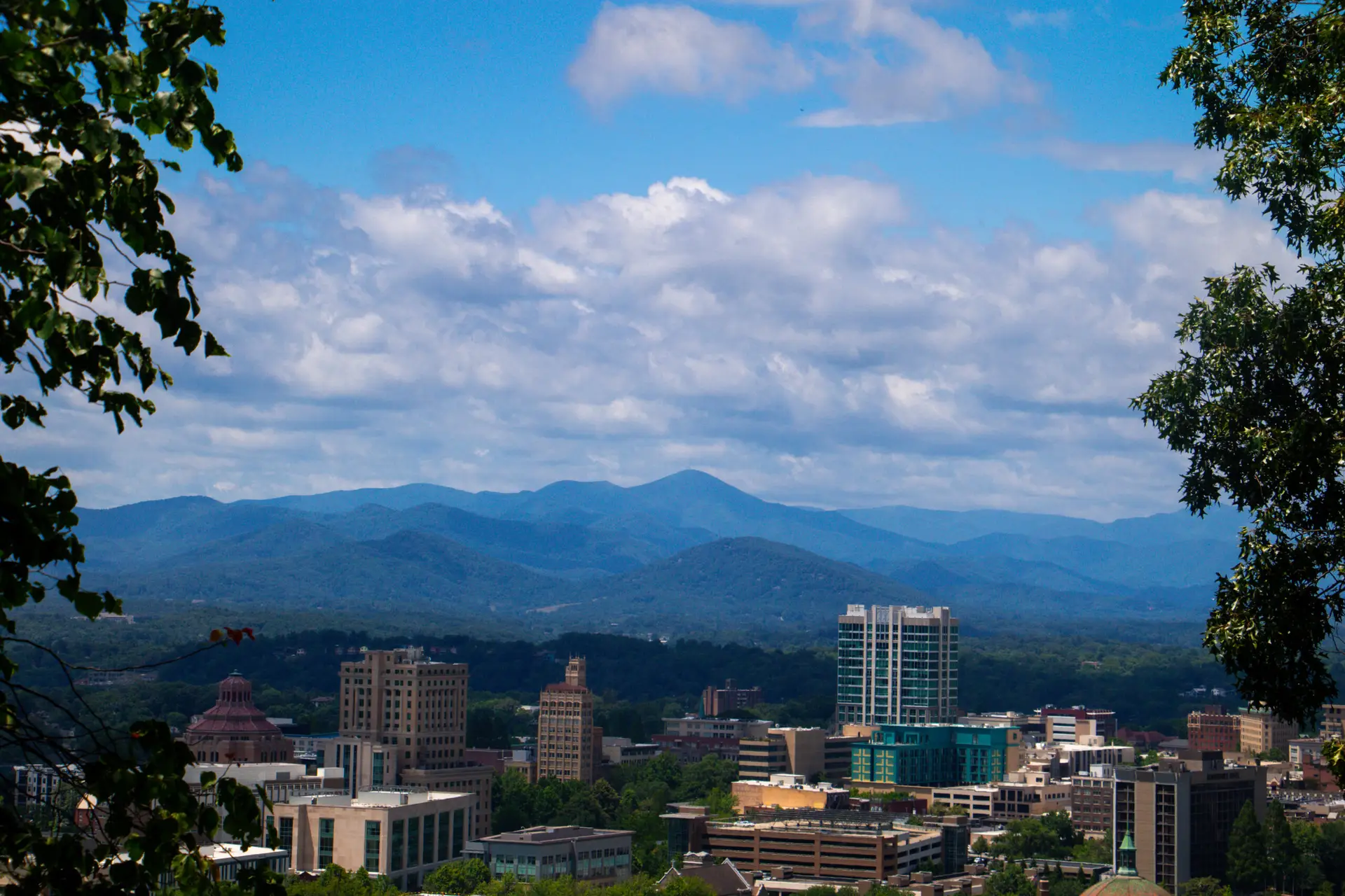 the city of asheville with mountains in the background